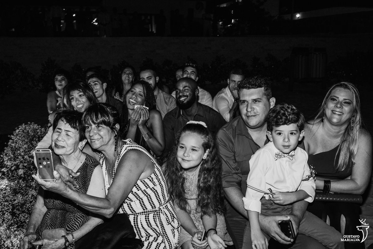 convidada abraça a avó do noivo emocionado com os convidados sorrindo durante a cerimônia de casamento no Uniq Beach Lounge em Búzios