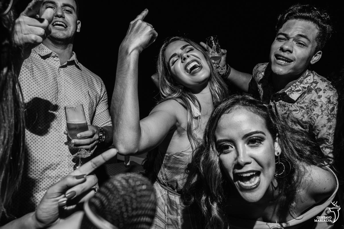 convidadas animadas e sorrindo cantam no microfone no Uniq Beach Lounge em Búzios