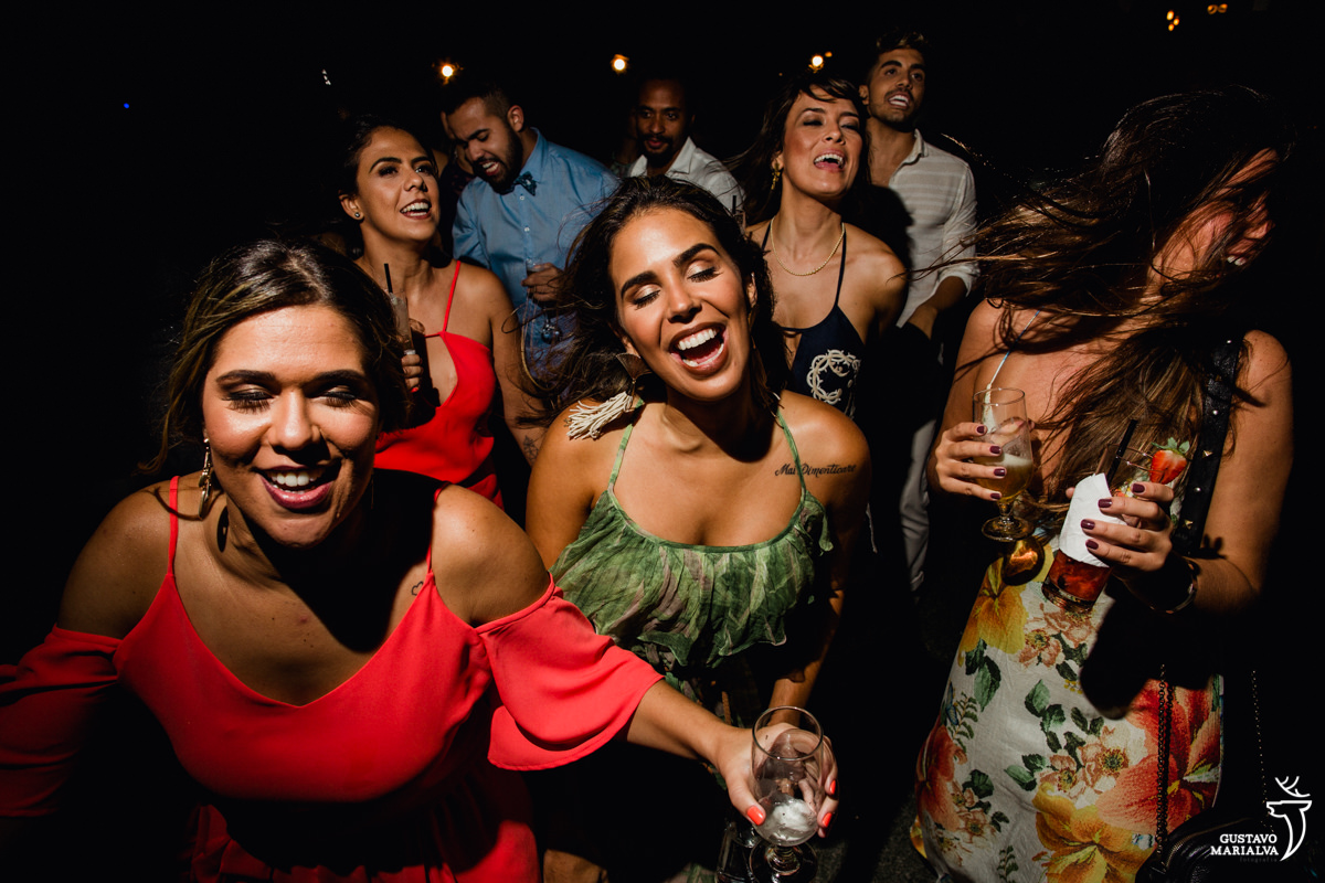 convidadas sorridentes dançam na festa de casamento no Uniq Beach Lounge em Búzios