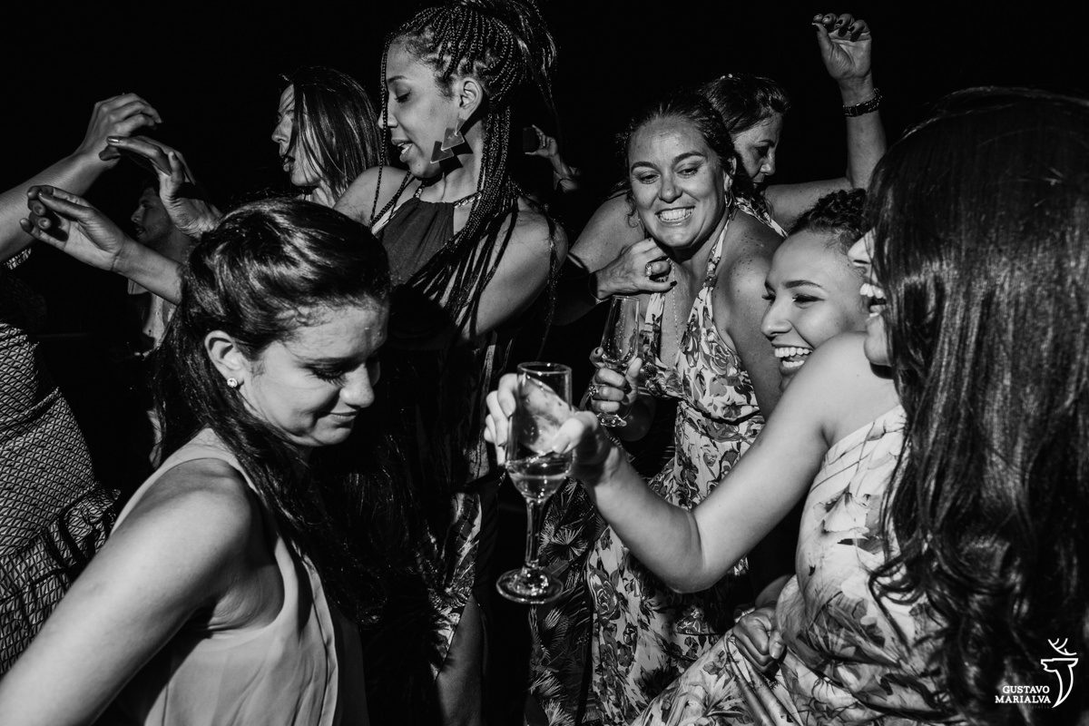 amigas dançam funk com taça de espumante na mão no Uniq Beach Lounge em Búzios