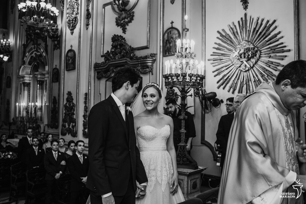 noiva olha sorrindo para o noivo durante a cerimônia de casamento na igreja são josé
