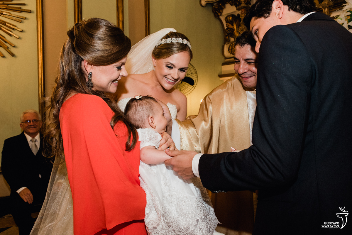 noiva emocionada recebe as alianças da irmã e da sobrinha durante a cerimônia de casamento na igreja são josé