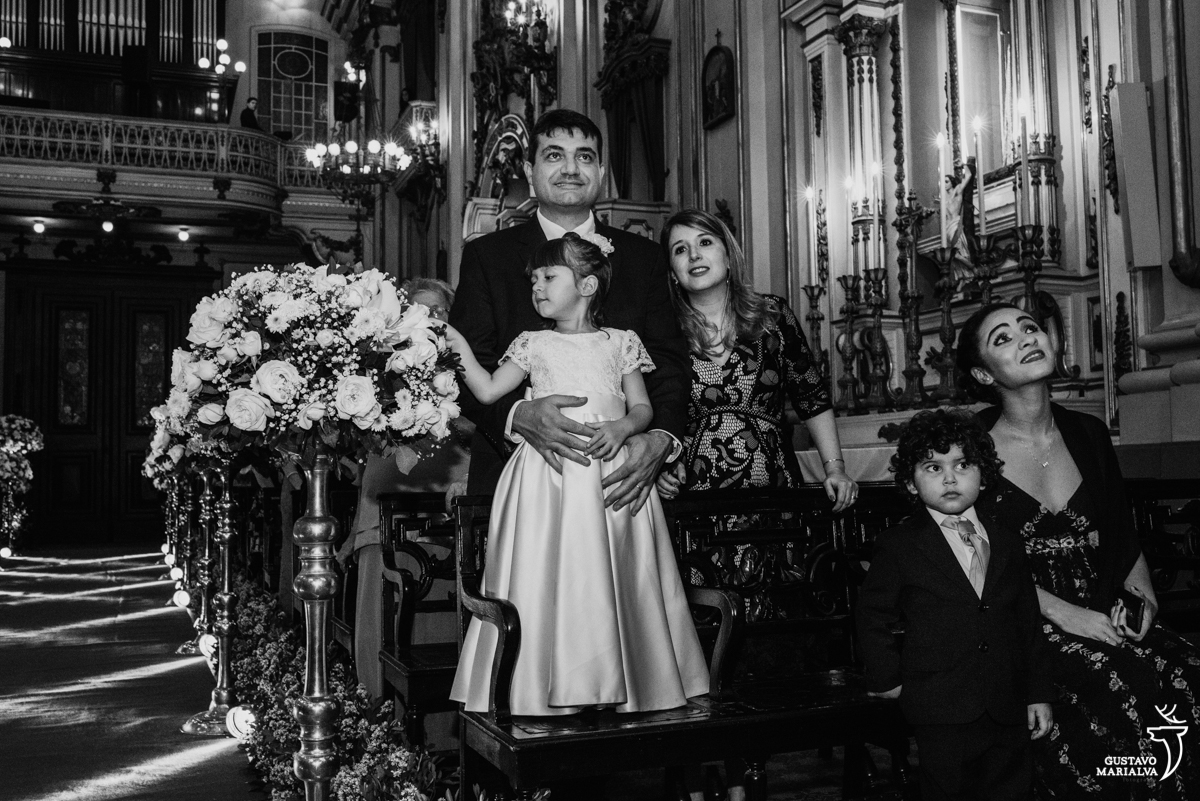 daminha brinca com as flores enquanto pajem e convidados observam a cerimônia de casamento na igreja são josé