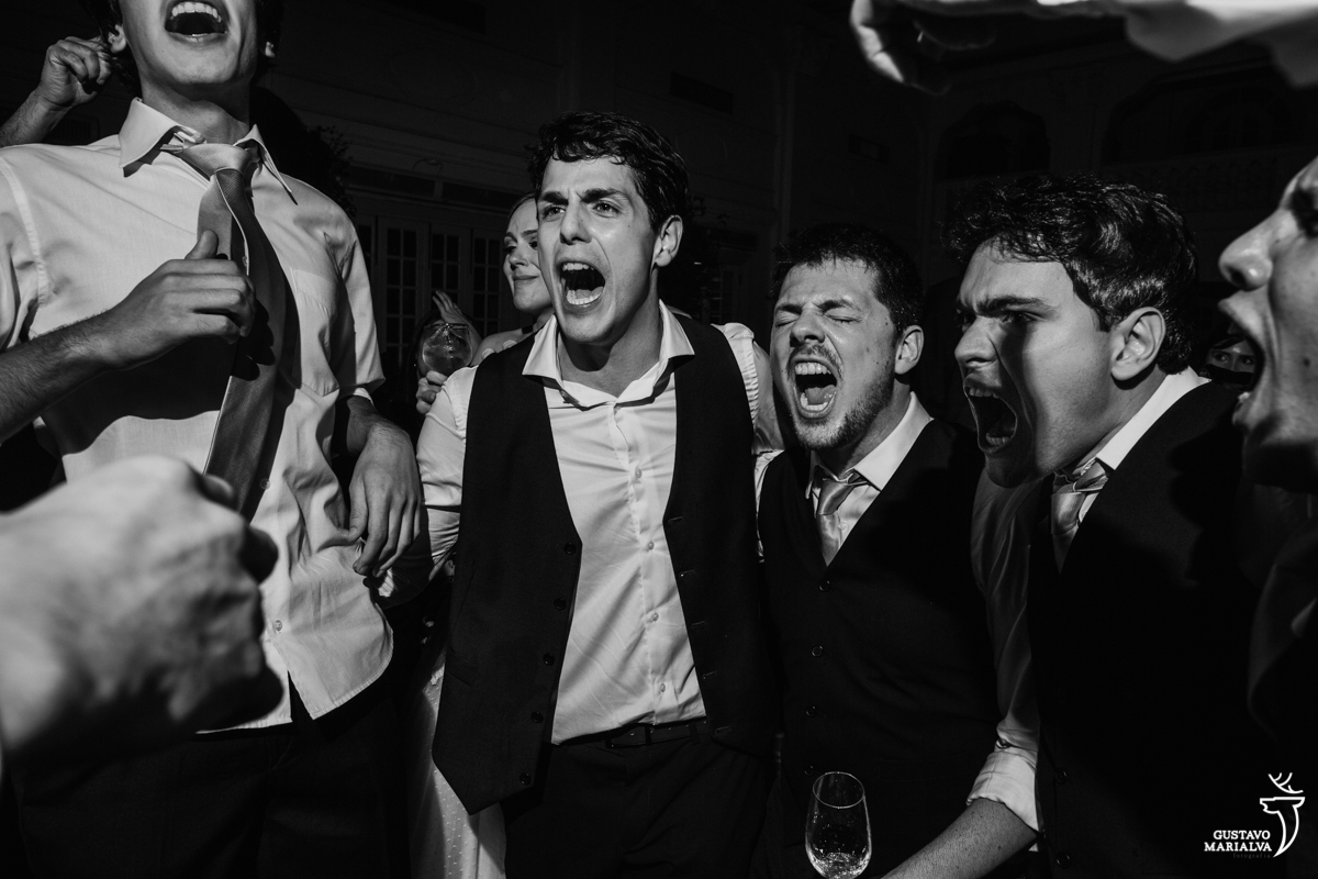 noivo canta empolgado abraçado com os amigos e padrinhos na festa de casamento na mansão botafogo