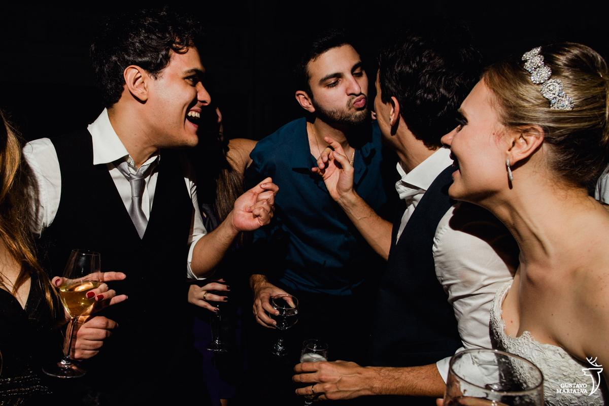 convidado finge dar um beijo no noivo enquanto noiva e amigos sorriem na festa de casamento na mansão botafogo