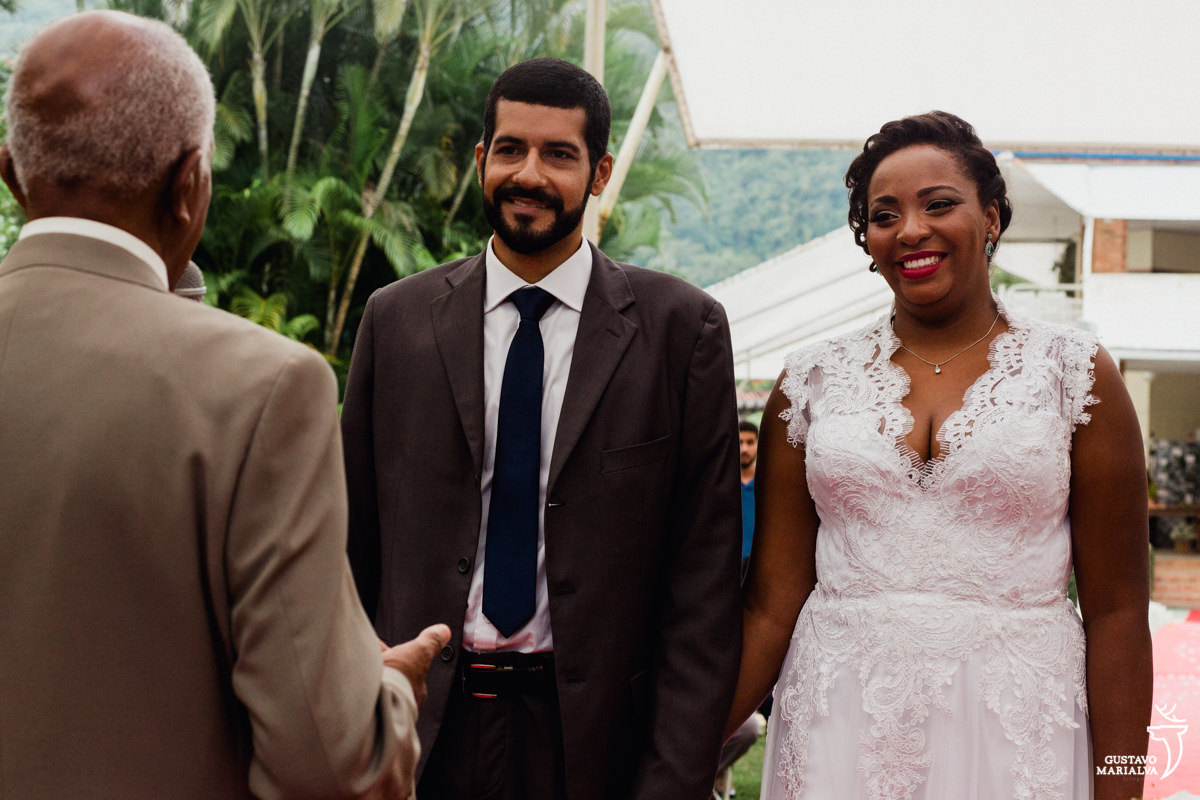 noivos sorriem com a cerimônia de casamento celebrada pelo avô