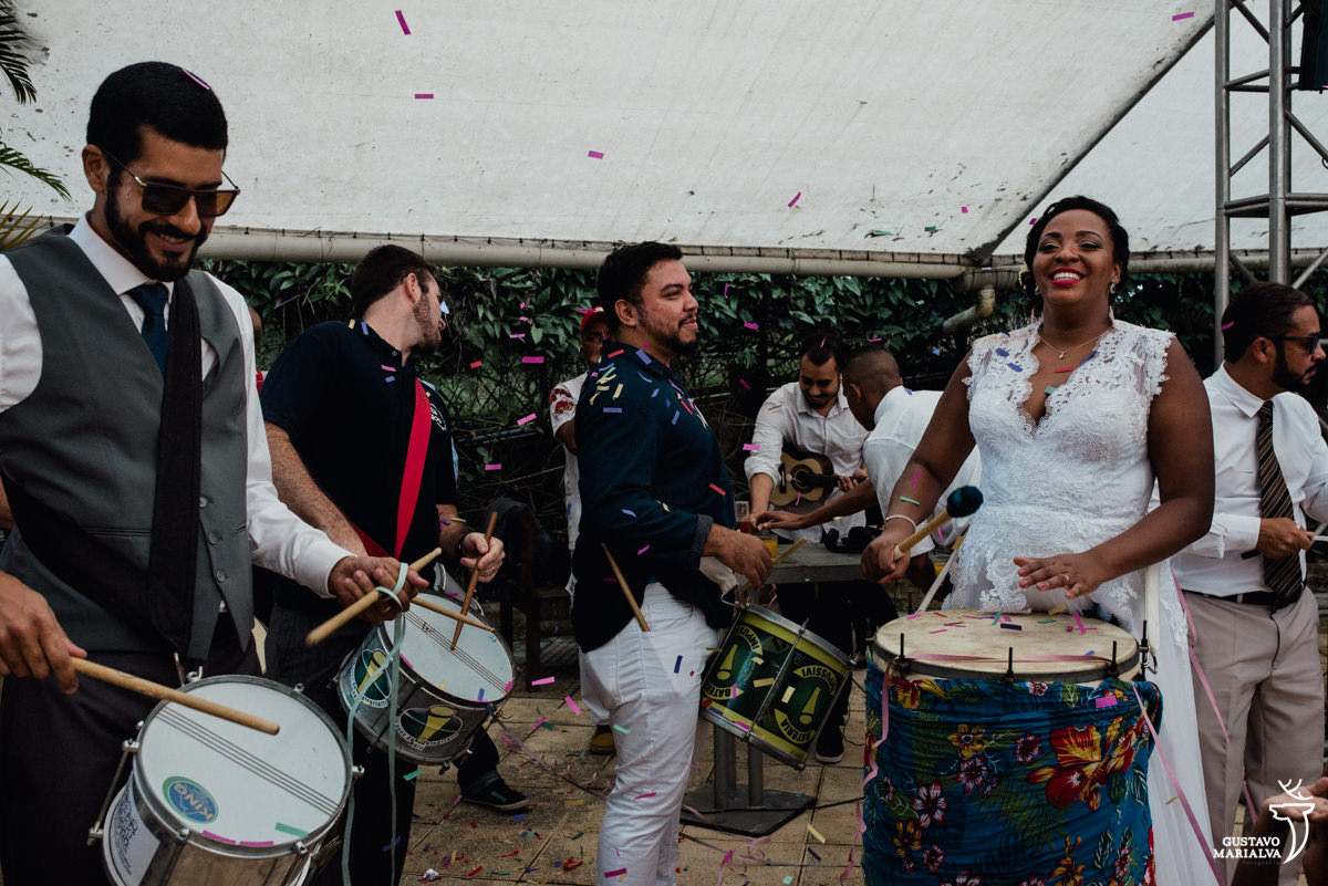 bloco de carnaval toca na festa de casamento com a noiva tocando surdo e o noivo tocando caixa