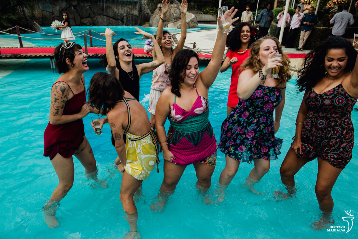 convidadas sorrindo dançam dentro da piscina