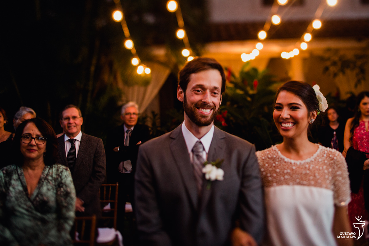 noivos sorriem emocionados durante a cerimônia de casamento
