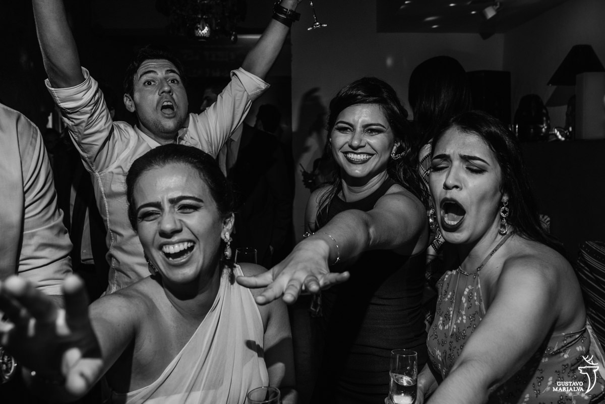 amigas gritam sorrindo enquanto convidado faz careta ao fundo