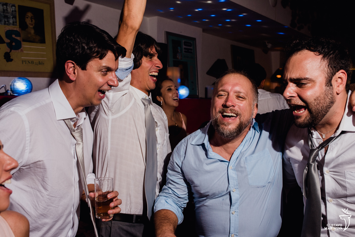 amigos dançam com copo na mão sorrindo no hotel santa teresa