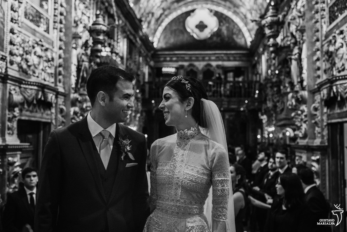 noivos se olham e sorriem durante a cerimônia de casamento