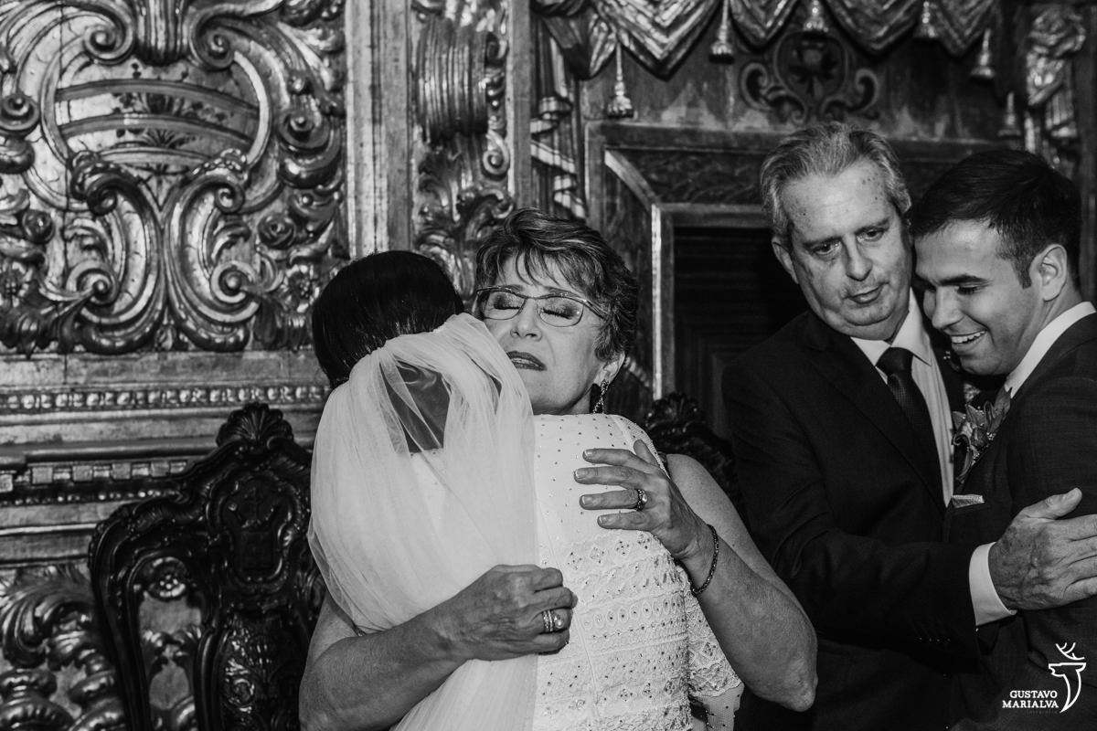 noiva abraça a mãe emocionada e noivo abraça o sogro