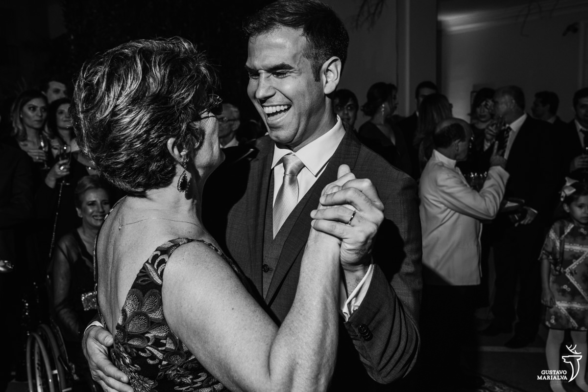 noivo sorridente dança com a mãe da noiva