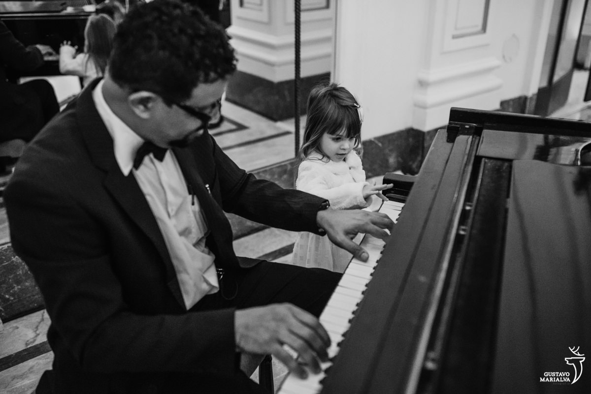 daminha observa músico tocar o piano