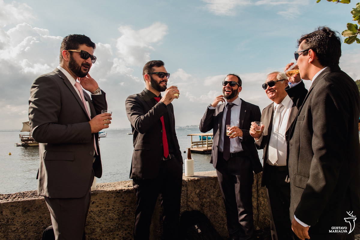 noivo e amigos e padrinhos tomando cerveja de óculos escuros na mureta da urca