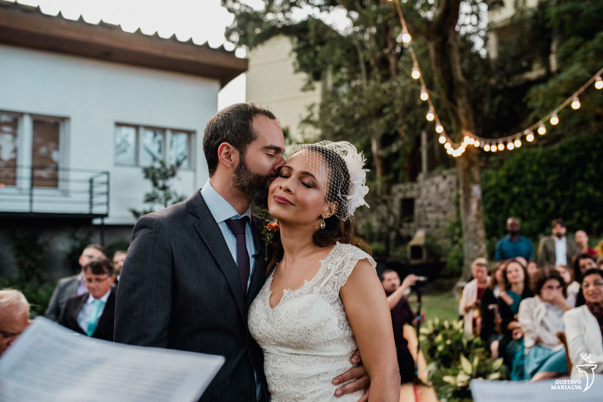 noivo beijando a noiva de olhos fechados