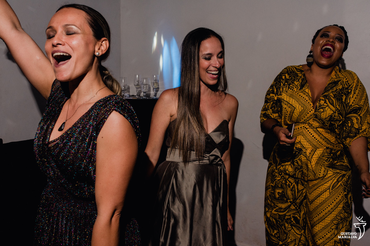 amigas dançando sorridentes com copo na mão