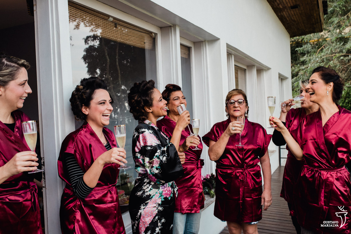 noiva e madrinhas brindam sorrindo com copo na mão no making of do casamento