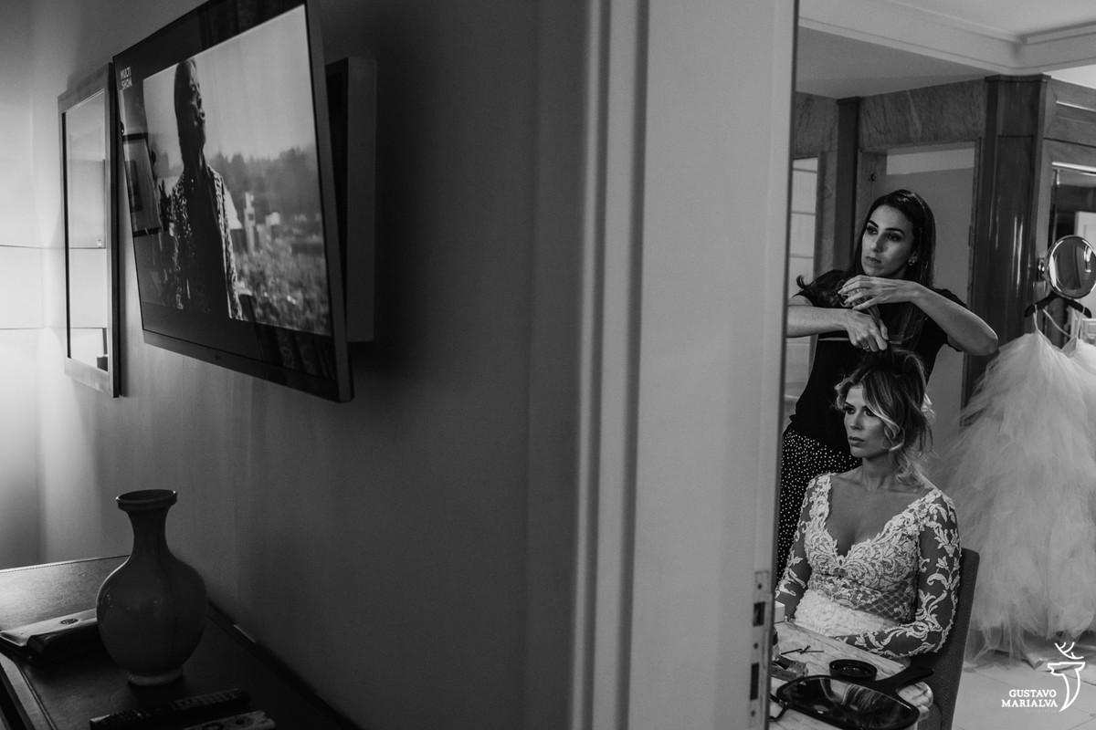 noiva arrumando cabelo no banheiro com show do mick jagger passando na tv