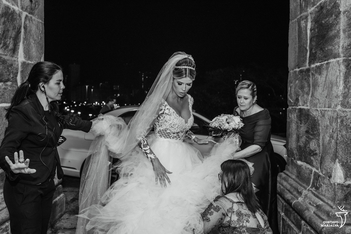 mãe e tia da noiva arrumando o vestido antes de entrar na cerimônia do casamento no outeiro da glória