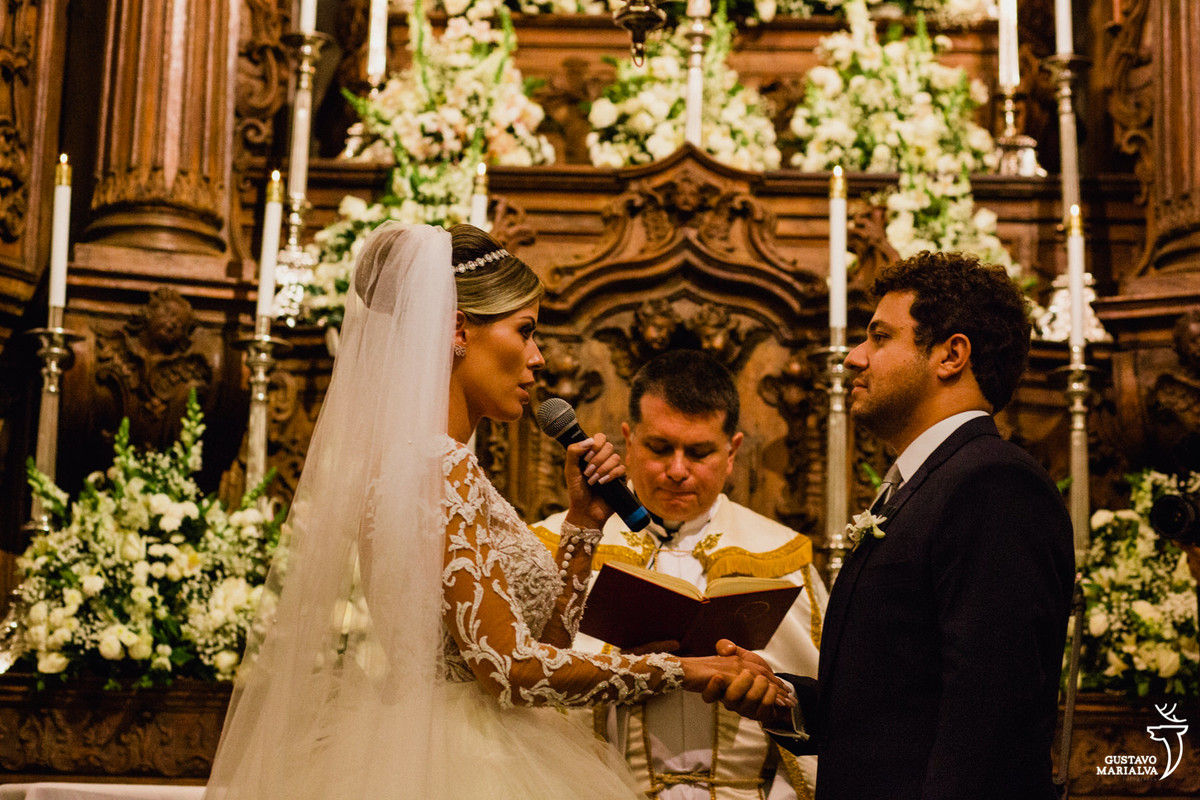 noiva lendo os votos segurando a mão do noivo na cerimônia do casamento