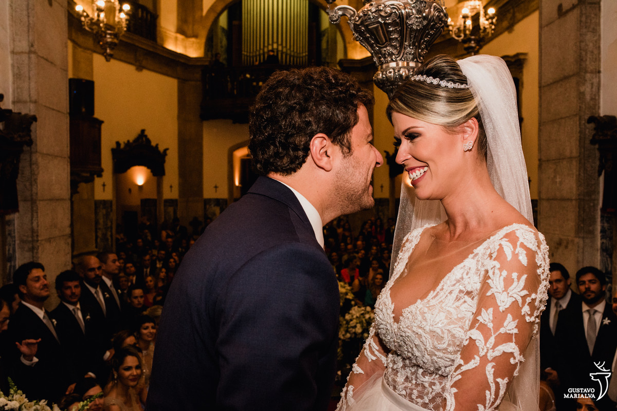 noivos sorriem de rosto colados na cerimônia de casamento