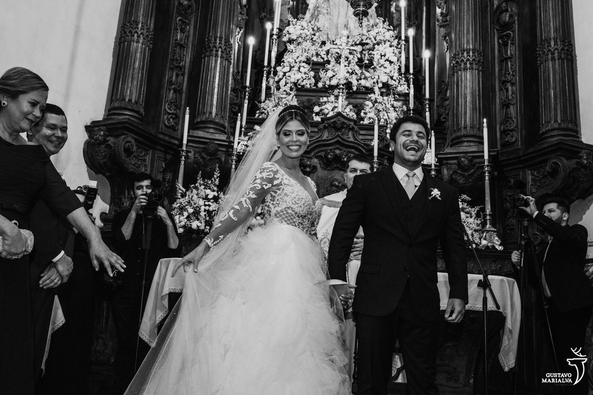 noivos sorriem de boca aberta e pais aplaudem durante a cerimônia de casamento no outeiro da glória