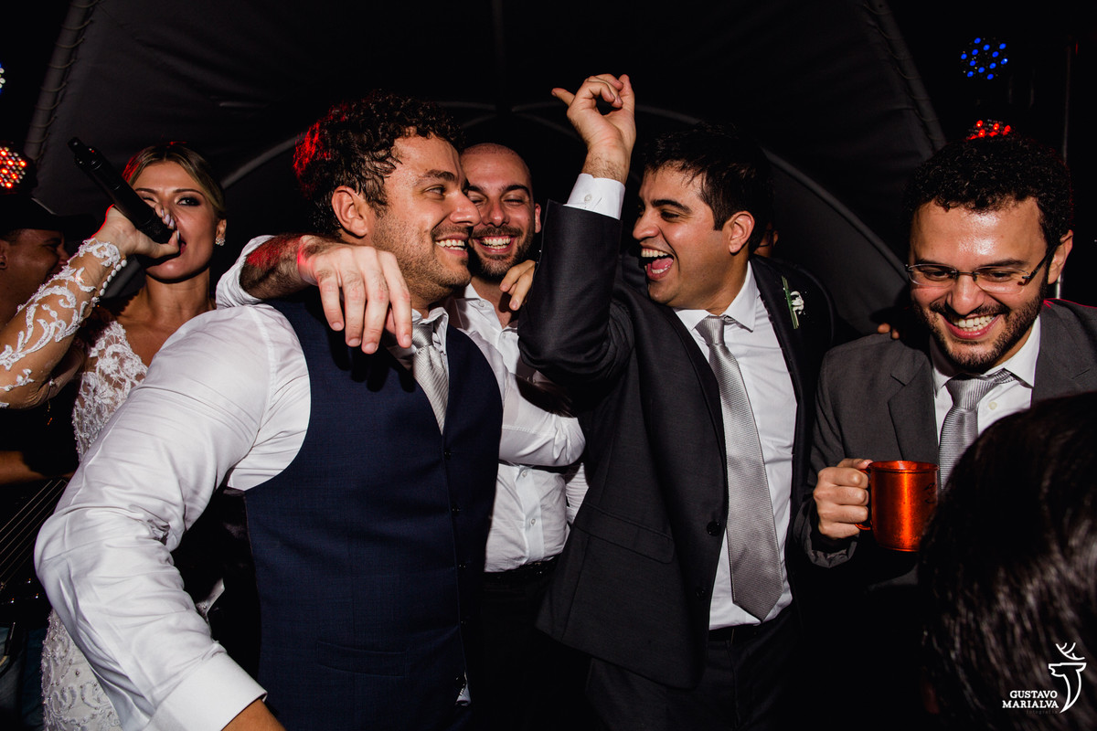 noivo é abraçado pelos amigos sorrindo