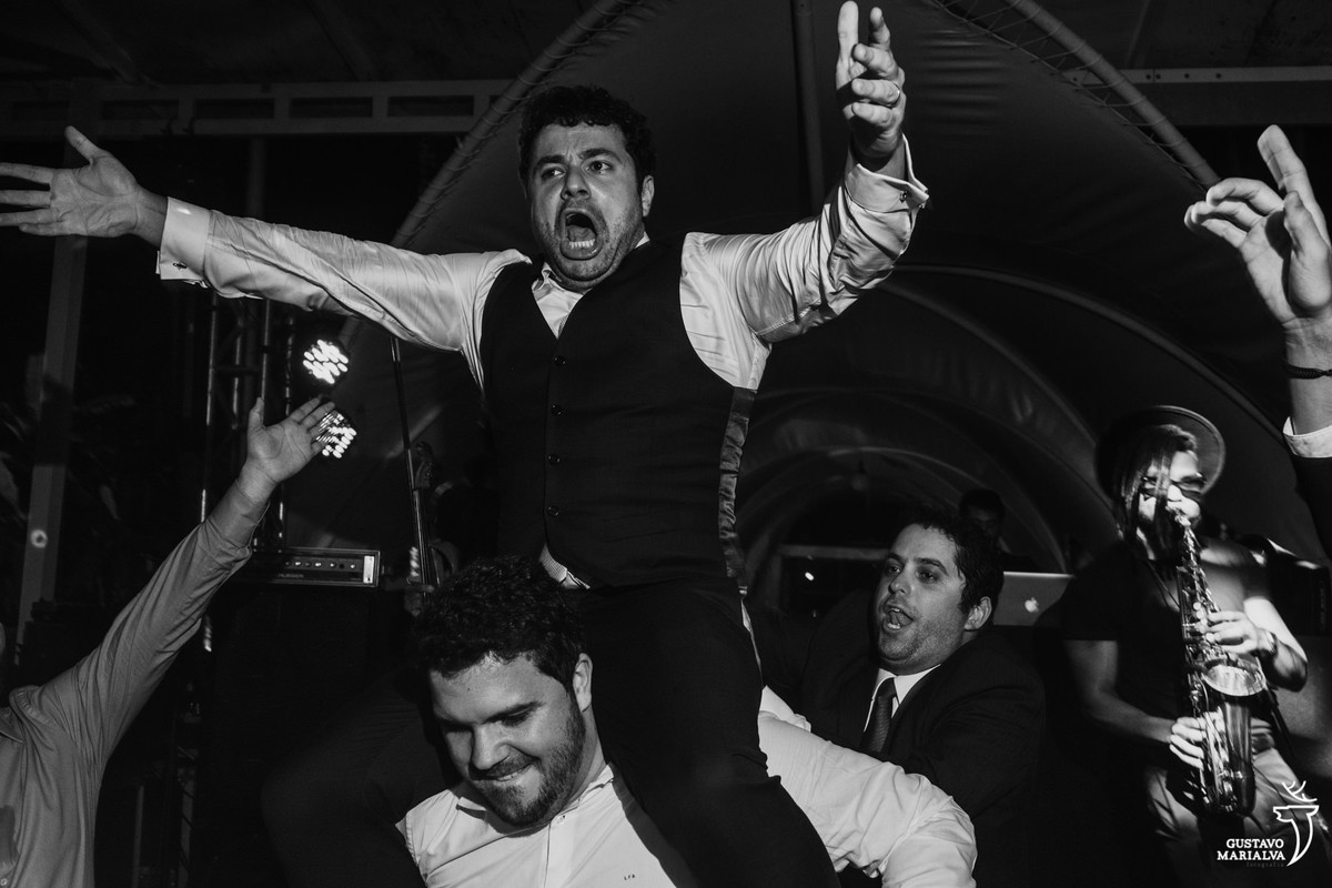 amigo carrega noivo nas costas que grita e faz careta