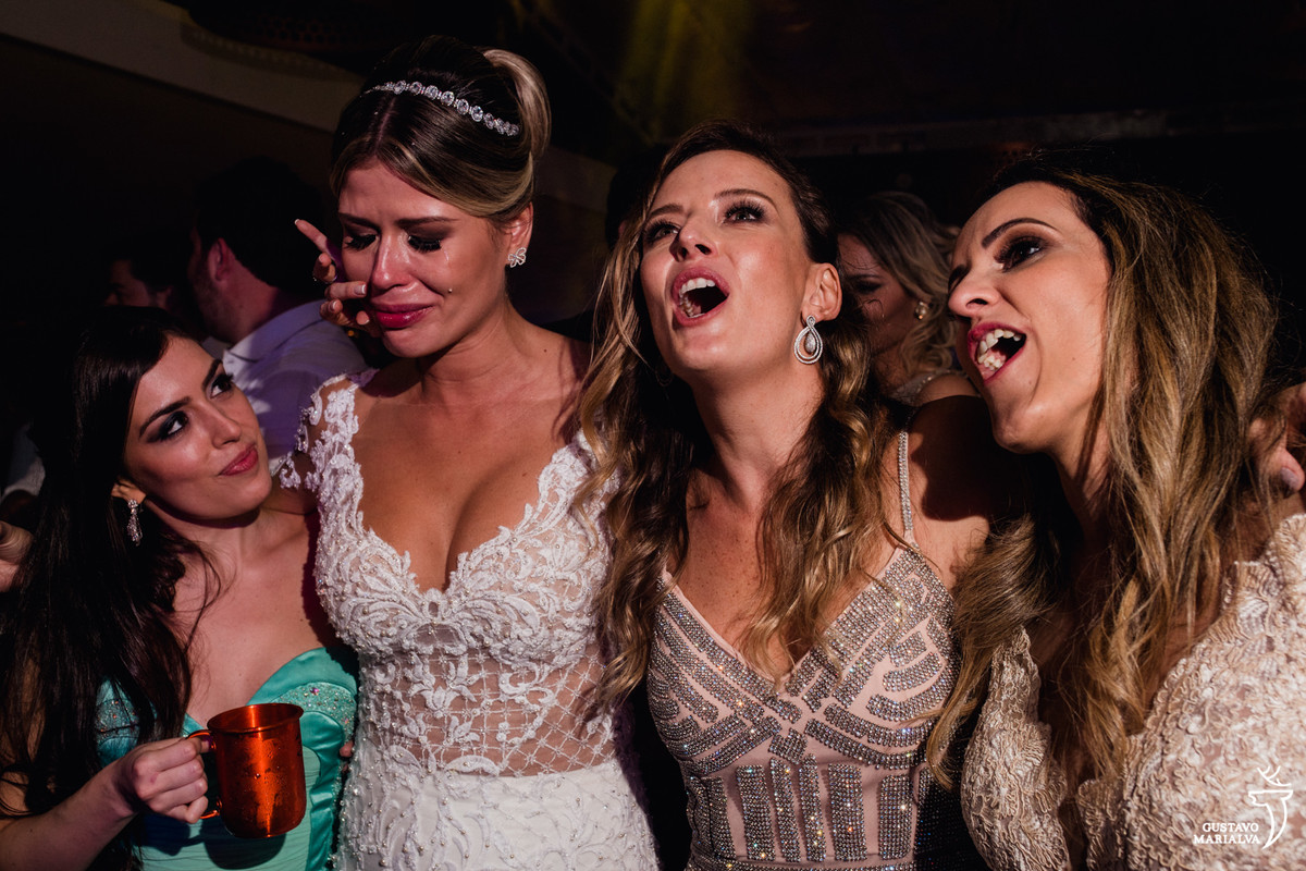 noiva chora emocionada e amigas abraçam e enxugam suas lágrimas
