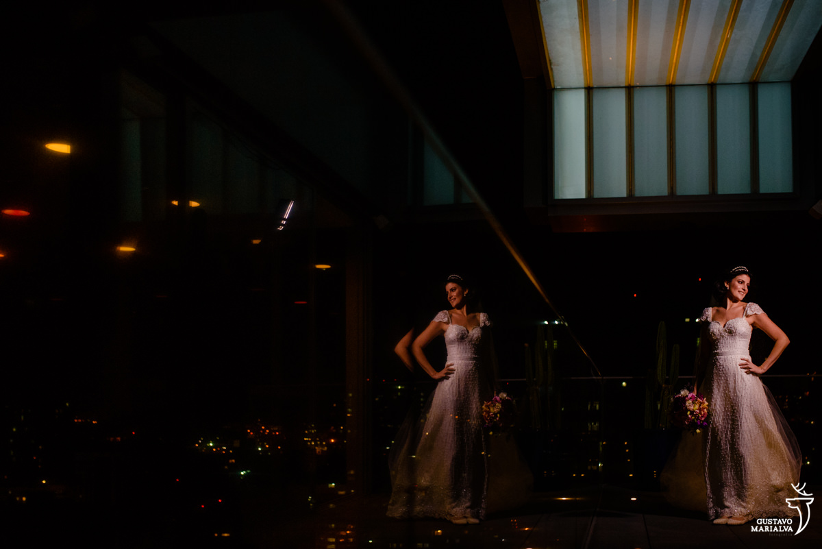 noiva posando na varanda do h hotel em niterói segurando o buque de noiva
