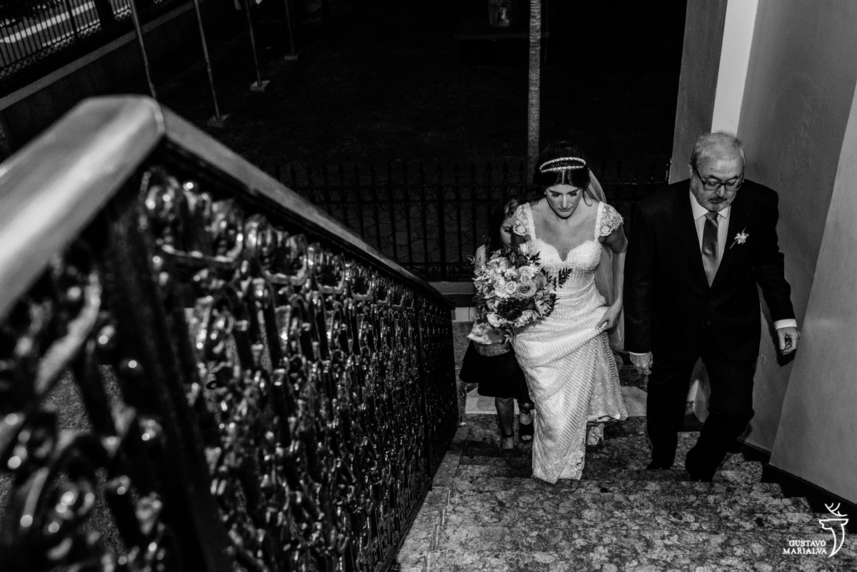 noiva e pai da noiva subindo as escadas da igreja do colégio são vicente em niterói