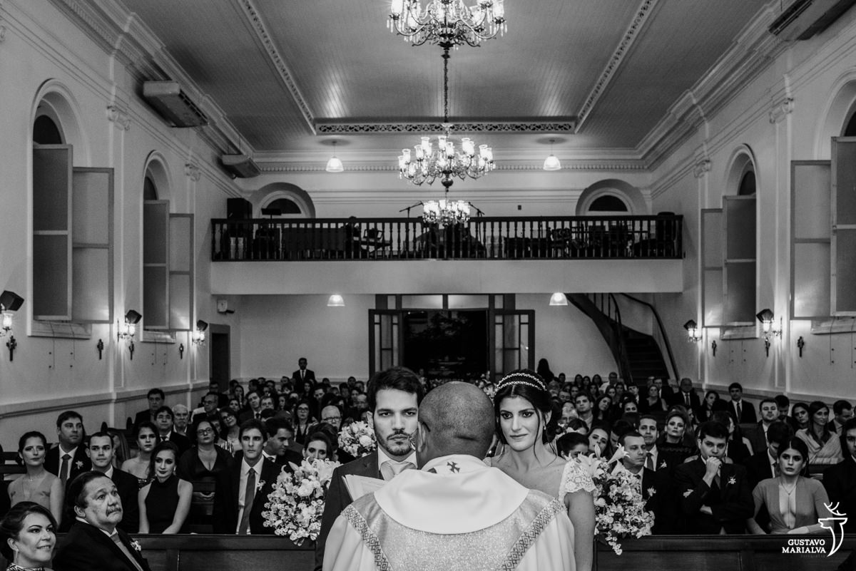 casal olhando fixamente para o padre durante a cerimônia de casamento