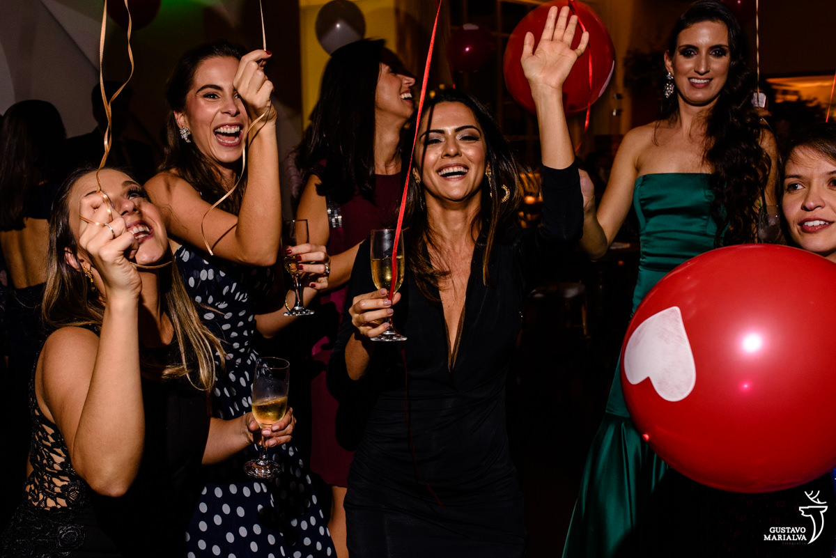 amigas dançando com balões de coração nas mãos