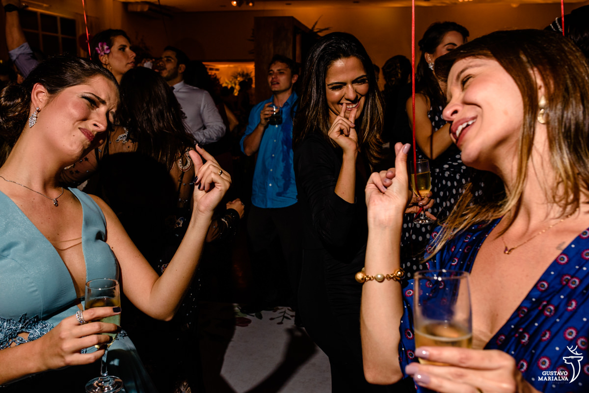 amigas dançando fazendo gesto com as mãos