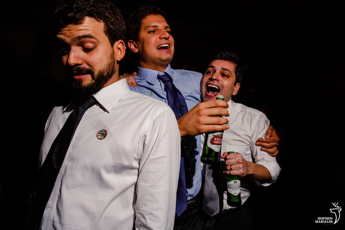 amigos se abraçam e pulam com garrafa de cerveja nas mãos