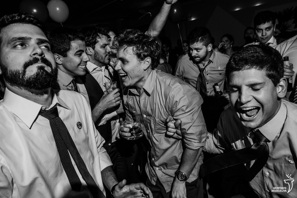 amigos dançam juntos com bebida nas mãos e sorrindo