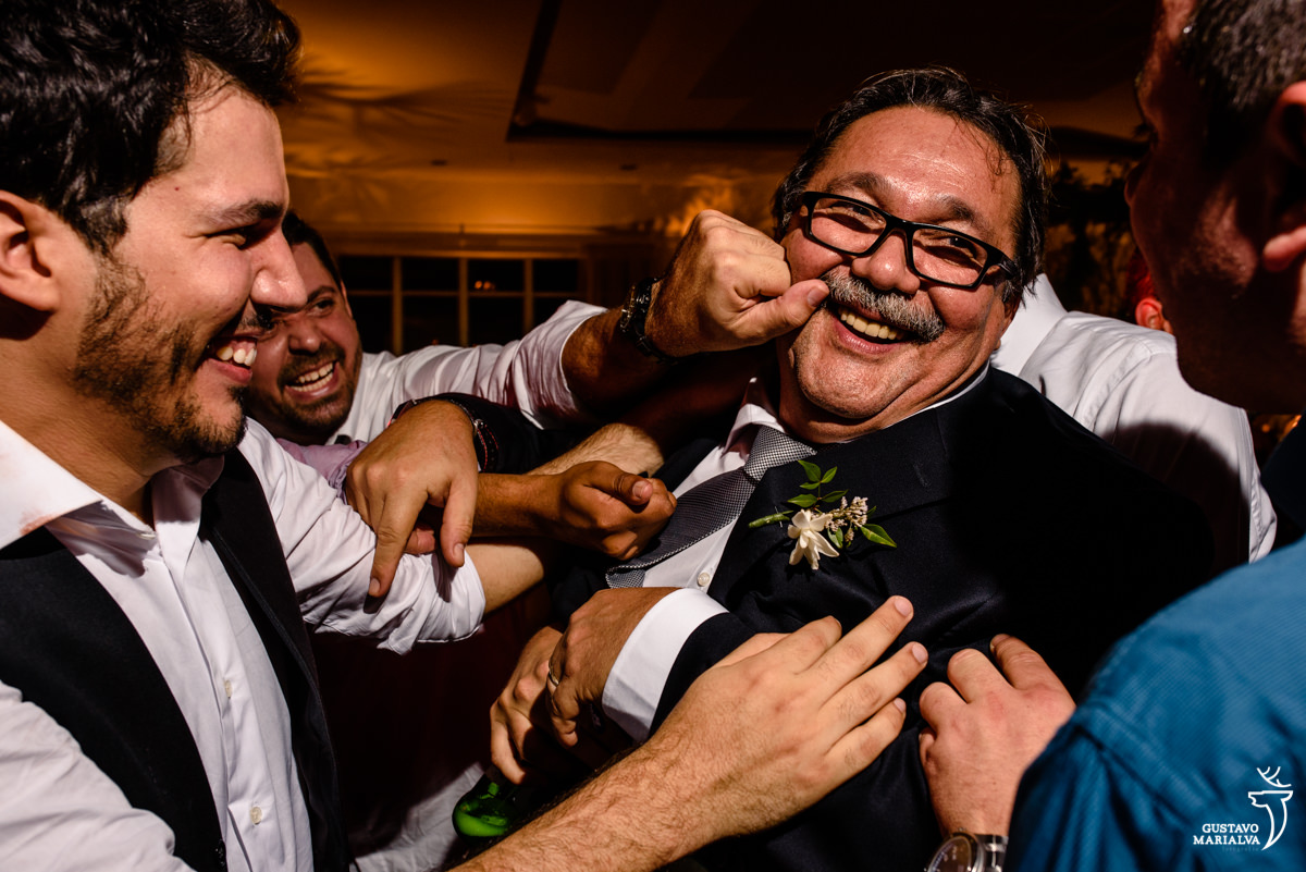 rapazes apertam a bochecha de senhor de bigode e óculos