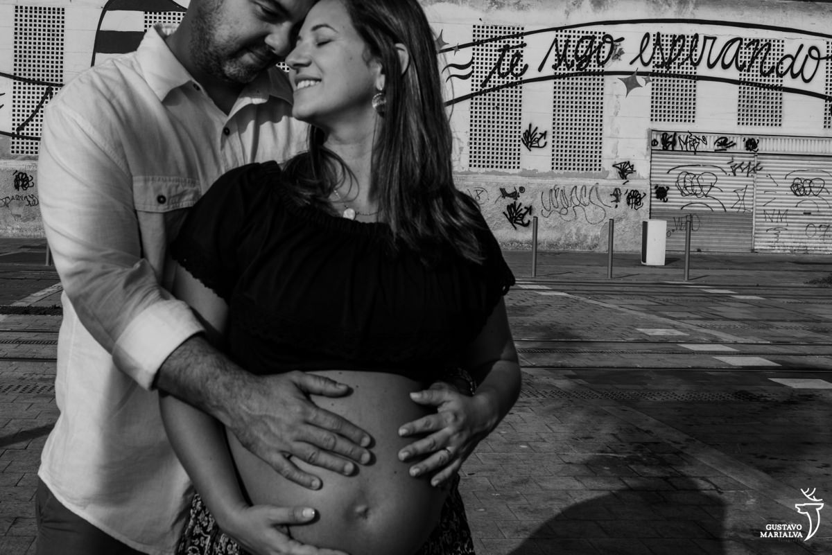 homem abraça gestante por trás com a mão na barriga
