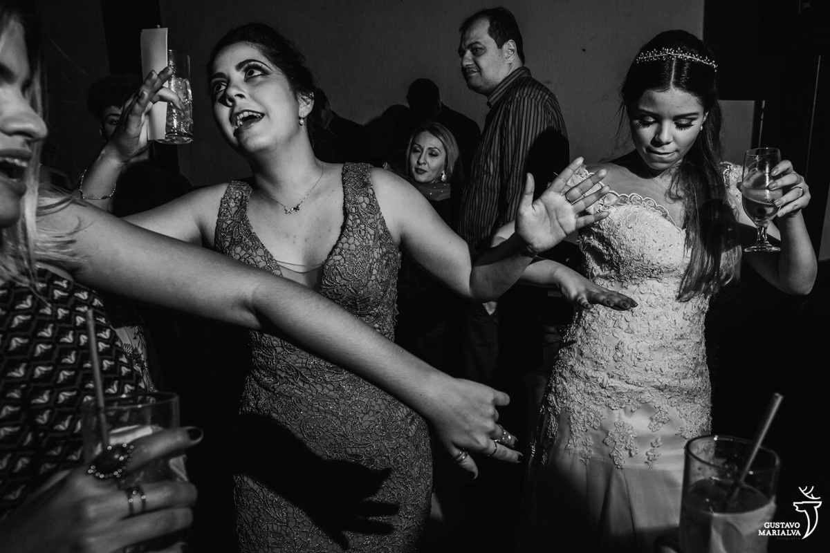 noiva e amiga dançam de braços abertos na pista de dança do casamento