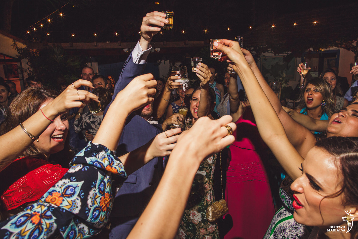 noivos e convidados fazem brinde com shots de cachaça