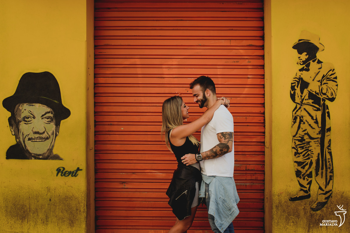 casal se abraça em frente a portão laranja durante book de casal realizado em curitiba