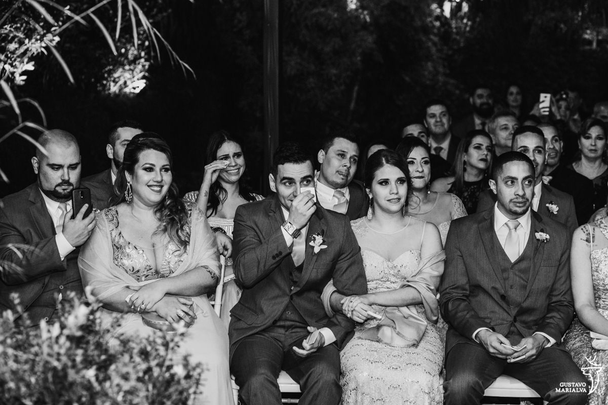 convidados choram, passando o lenço nos olhos e sorrindo durante a cerimônia de casamento