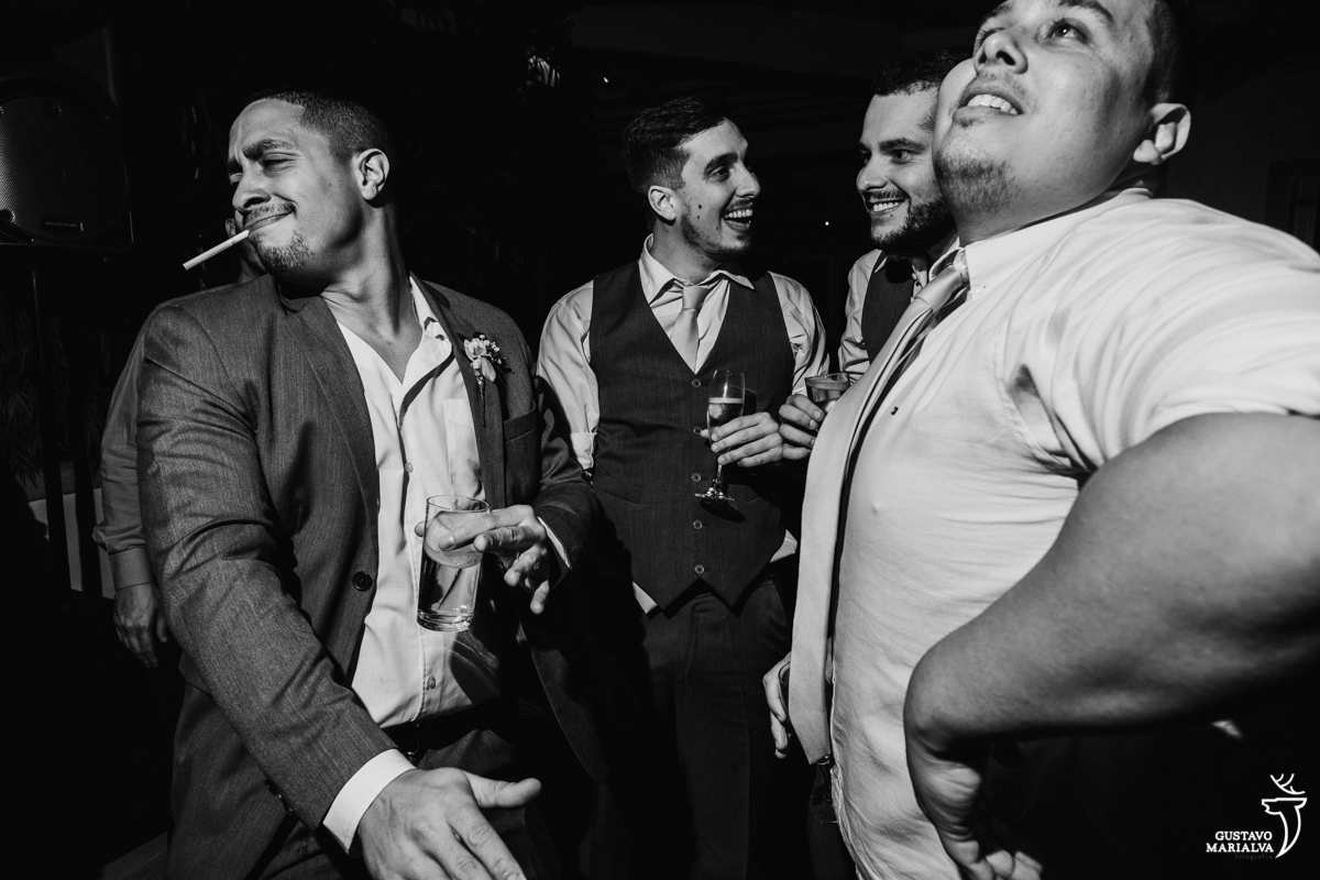 convidado faz careta com cigarro na boca e amigos sorriem