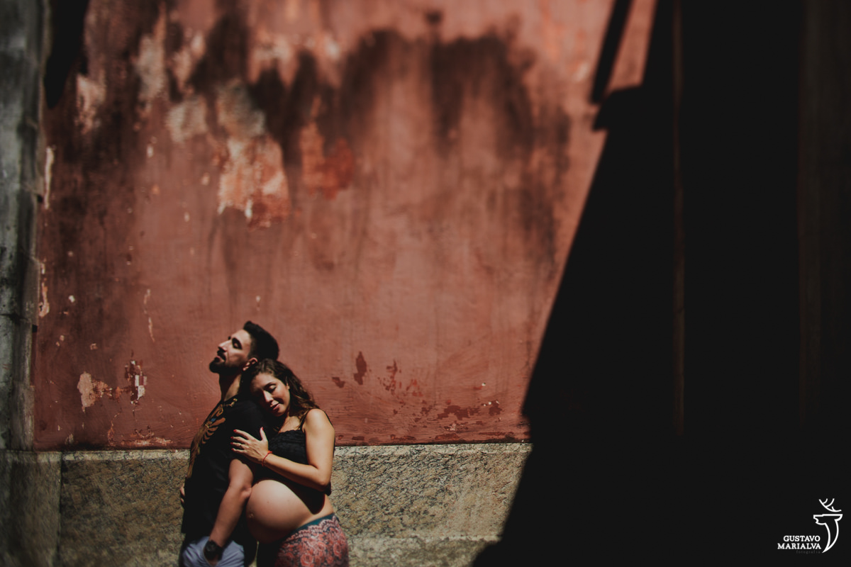 mulher grávida abraça homem por trás
