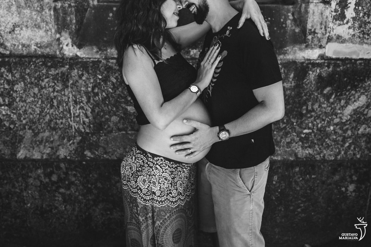 casal de grávidos se abraça sorrindo