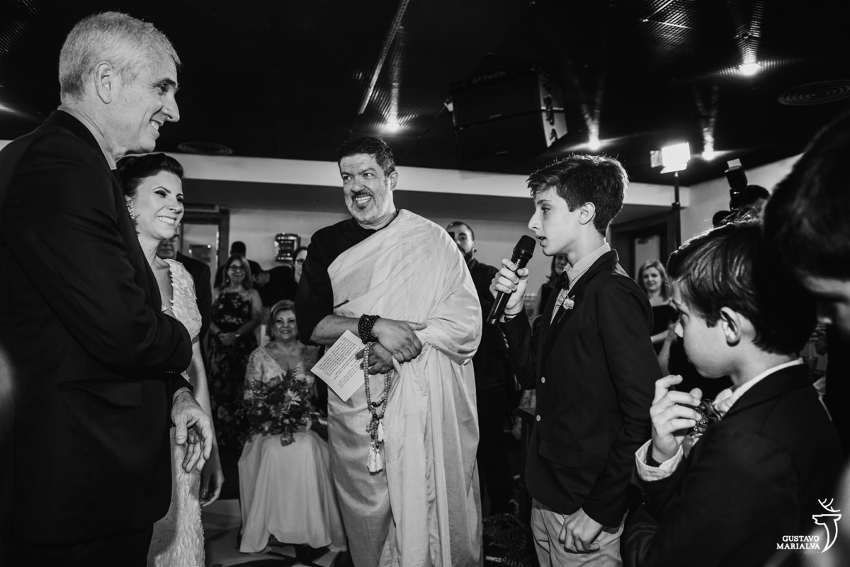 filho discursa para o pai observado por monge budista durante a cerimônia de casamento