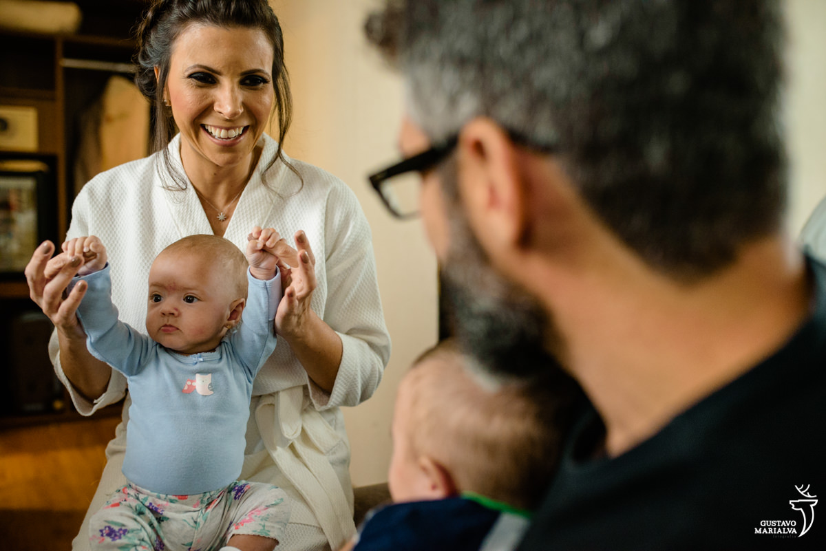 noiva sorri e brinca com bebê no colo