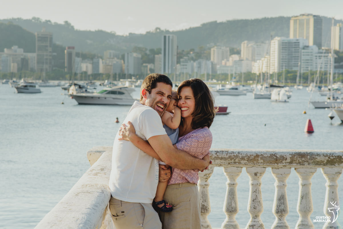 pais abraçam e espremem a filha durante ensaio de família realizado na urca